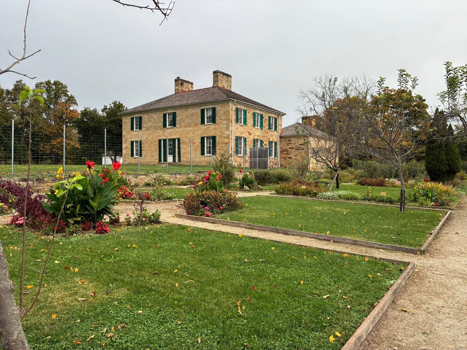 Full view of Adena Mansion with its garden paths and autumn landscape